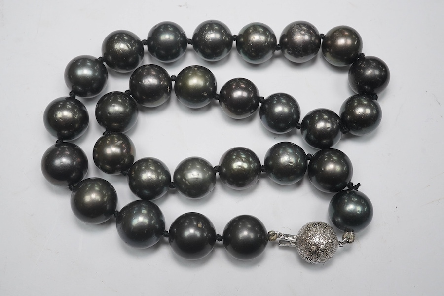 A modern single strand Tahitian black pearl necklace, with diamond cluster set 14k white metal spherical clasp, 40cm. Condition - fair to good